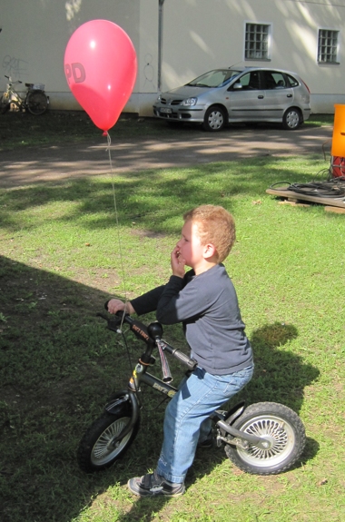 Kind auf Fahrrad mit Luftballon