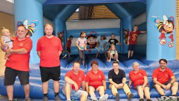 Kinder in der Hüpfburg und davor die Organisatoren mit Kreisvorsitzenden Peter Wein | Bild: A. Michalski